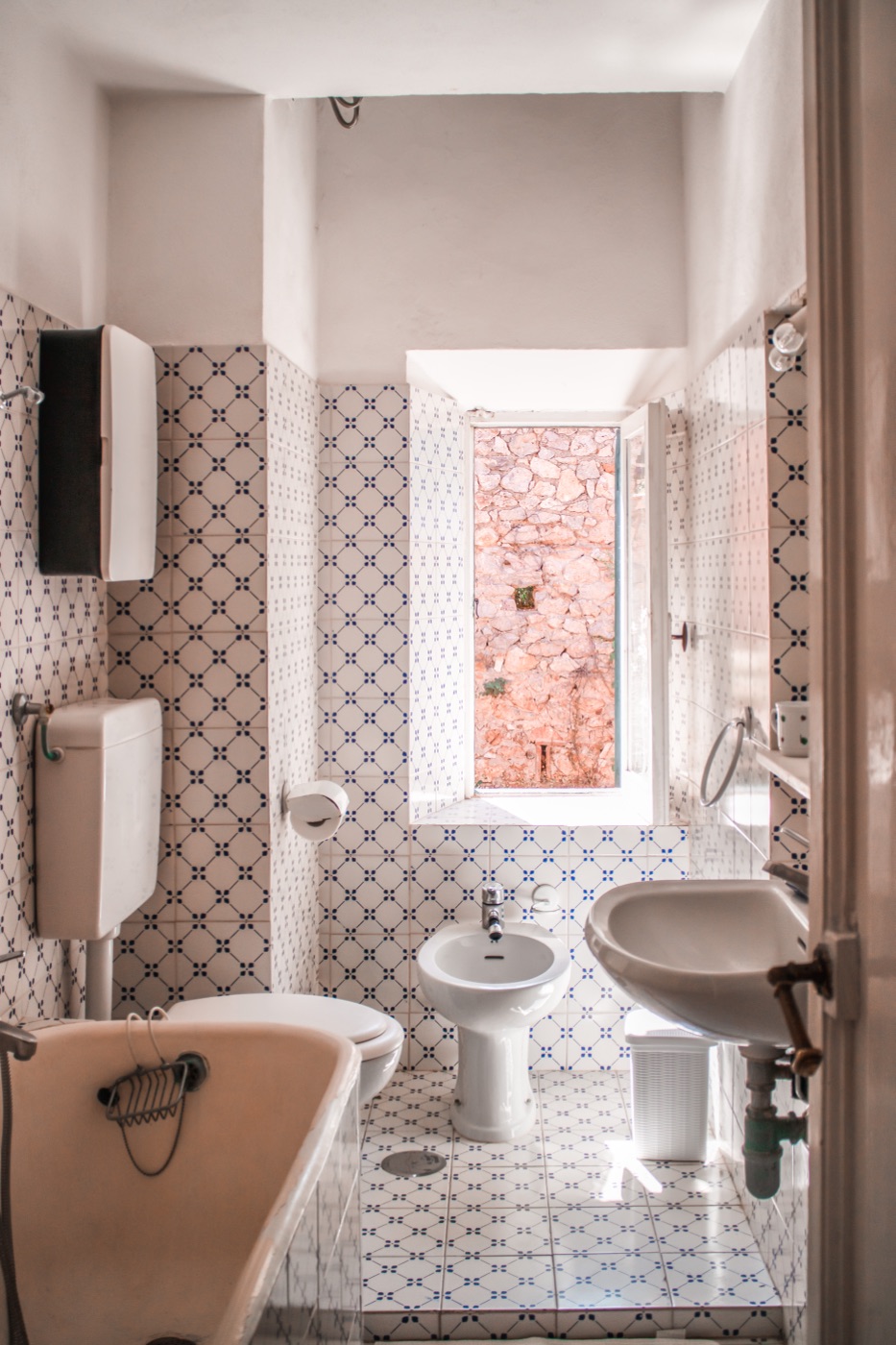 A bathroom with patterned blue and white tiles